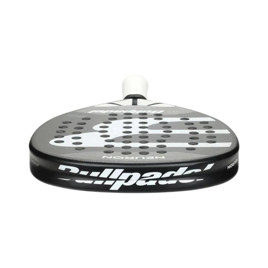 Close-up view of the BullPadel Padel Racket Neuron 2024 Fede Chingotto, featuring a black and white design with perforations and rounded edges. It has a light grip on the handle, Vibradrive for comfort, and is built with Xtend Carbon 3K for enhanced performance.