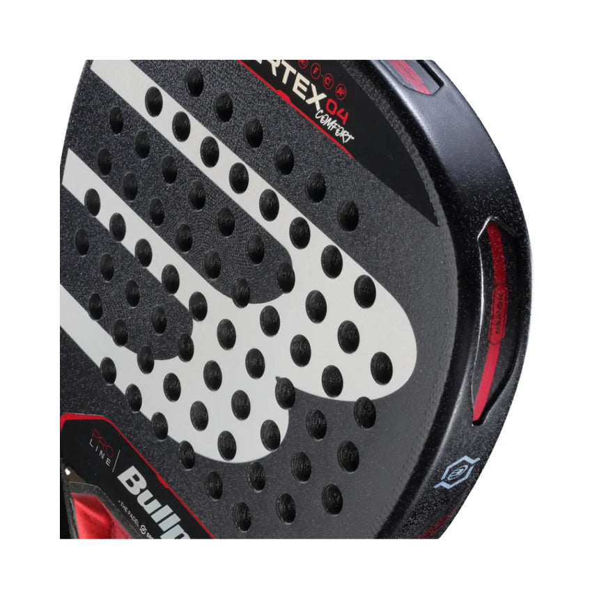 Close-up of the Bullpadel Vertex 04 Comfort 2024 Martín Di Nenno racket: black, diamond-shaped with gray polka dots and red accents. BullPadel partly visible at the bottom. Features Top Spin surface and textured edges with CURVAKTIV system for superior play.
