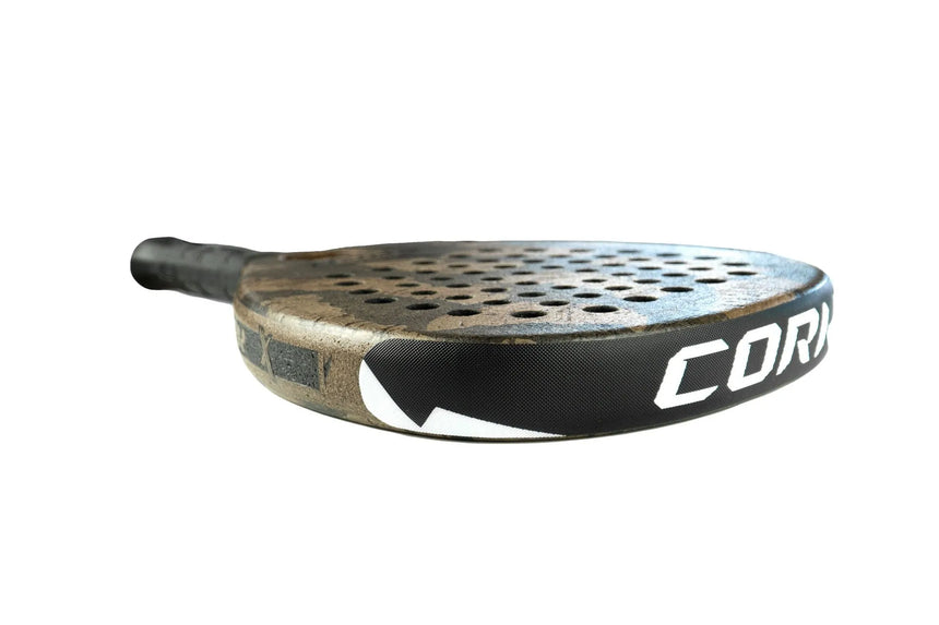 The Cork Padel Extreme Black racket, by Cork Padel, features a sleek black and cork design with circular perforations for enhanced play. Its wrapped grip handle ensures comfort, making it a high-performance innovation that epitomizes style and functionality against a white background.