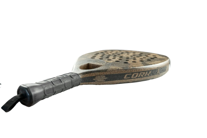 The Cork Padel Extreme Black racket exemplifies innovation with a textured black handle and brown perforated head. Cork Padel is prominently displayed on the side, emphasizing its unique design and premium materials.