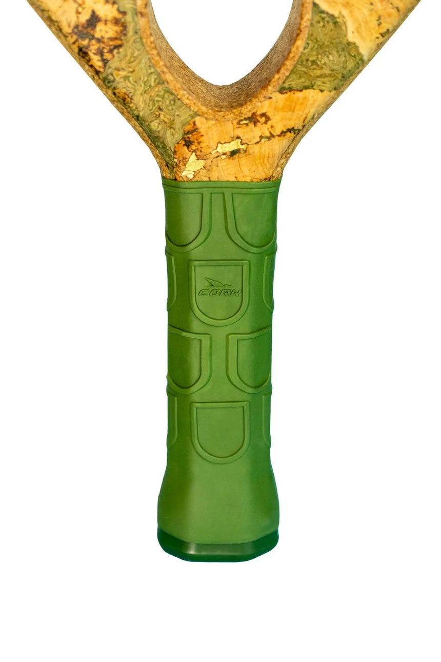 Close-up of Cork Padels Extreme Green slingshot with a Y-shaped wooden frame and green rubber grip. The textured grip features the Cork Padel logo and geometric patterns, while the wood has a natural, speckled appearance reminiscent of elegant limited edition rackets.