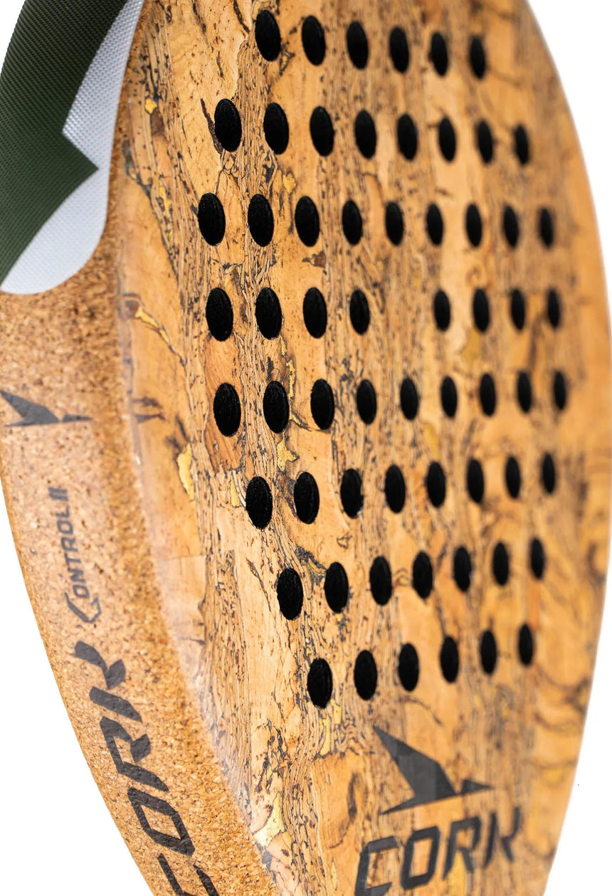 Close-up of the Cork Padel Supreme Control III, perfect for advanced players. It features a textured surface, black perforations, and bold CORK branding on the side, highlighting its control design. A small green fabric piece appears at the top edge.