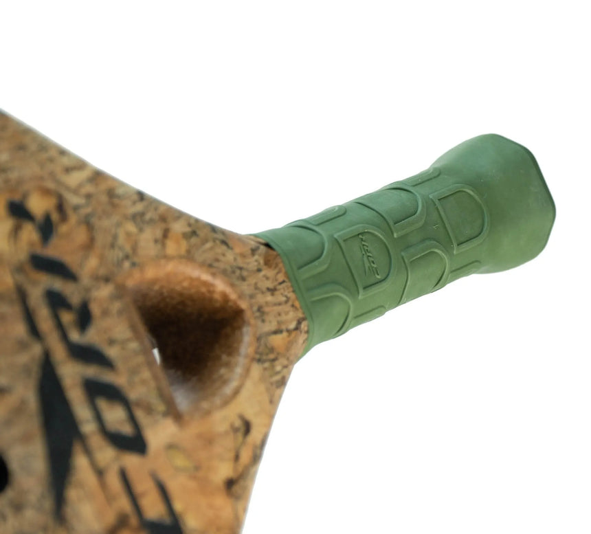 Close-up of a bicycle handlebar featuring a cork section with black text and a green ergonomic rubber grip. The high carbon composition enhances grip with its textured pattern, and the Cork Padel logo is embossed on it, reflecting supreme craftsmanship akin to the Cork Padel Supreme Power III.