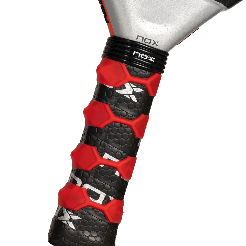 Close-up of the NOX Padel Racket AT10 Genius 18K by 2024 Agustin Tapia handle, featuring a black and red hexagonal pattern grip. The brand NOX is on the silver neck, crafted from refined aluminized carbon fiber for enhanced durability.