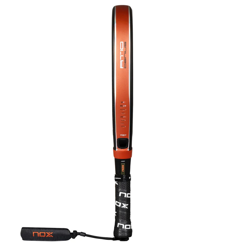 Side view of the Nox Padel Racket AT10 Genius Attack 12K 25 by Agustin Tapia, featuring a red and black frame. The handle with a black grip displaying NOX in white includes Exclusive Spin Technology, and a matching black vibration dampener is attached to its end.