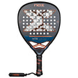 The Nox Padel Racket AT10 Genius Attack 18K Alum 2025 by Agustin Tapia features a black and orange design, crafted with 18K carbon. It has circular holes, an X design on the face, the brand NOX displayed at the top and handle, a black grip, and a wrist strap for optimal performance.