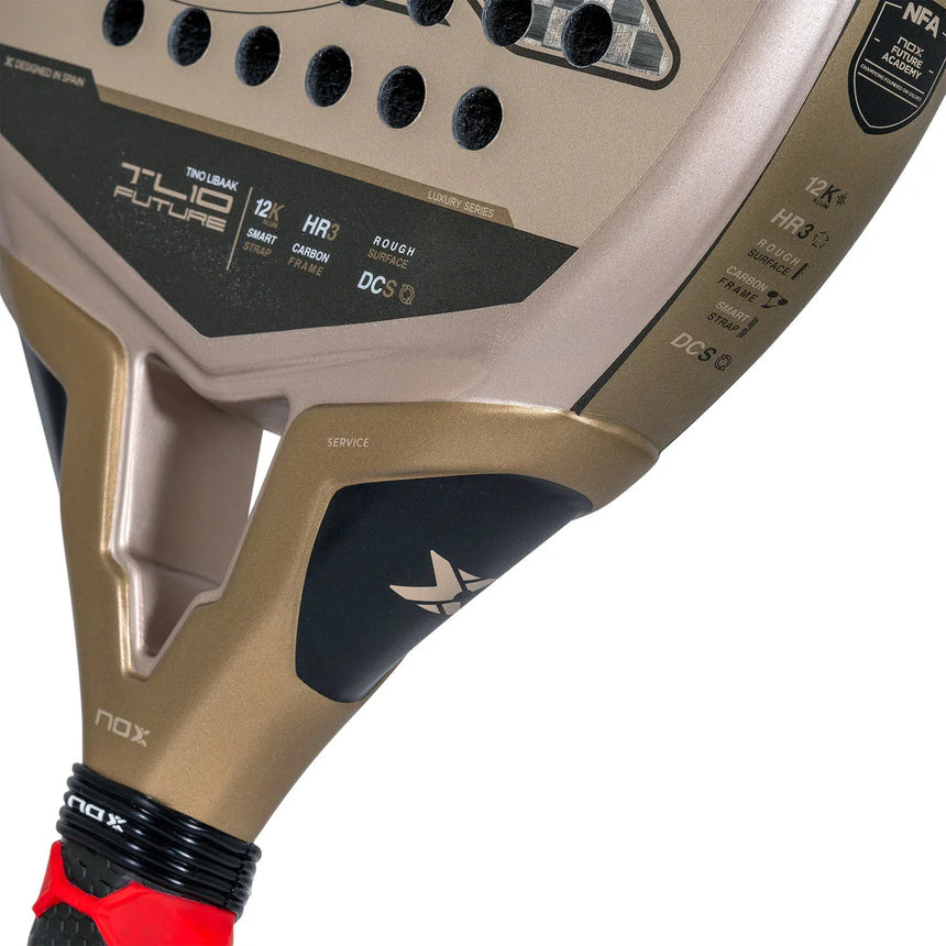 Close-up of a teardrop-shaped NOX Padel Racket TL10 Future 2024 Tino Libaak with a gold and black design, red-accented handle, and logo. Future and Nox text near the top. Made from aluminized 12K carbon fiber with black circular holes and textured patterns for versatile gameplay.