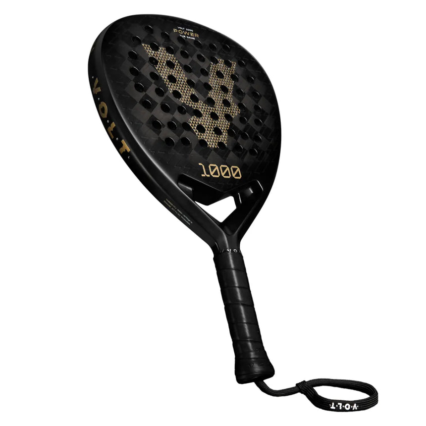 The VOLT 1000 v4 padel racket from Volt features a sleek black and gold design with a strong carbon structure. VOLT and 1000 v4 are highlighted on the shaft and face, while the handles black grip tape and strap provide excellent control and stability.
