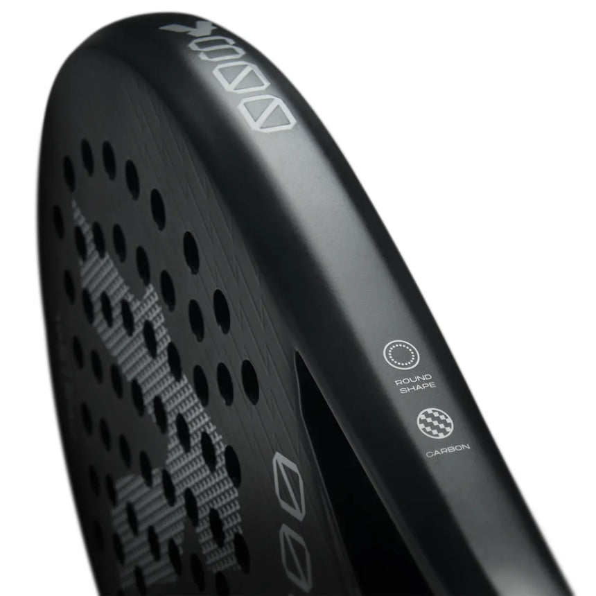 Close-up of the VOLT 800 V4 padel racket by Volt, showcasing its black 3K carbon structure with circular surface holes. The rim reads Round Shape and Carbon, featuring shock absorption technology. The design includes abstract patterns and geometric shapes.