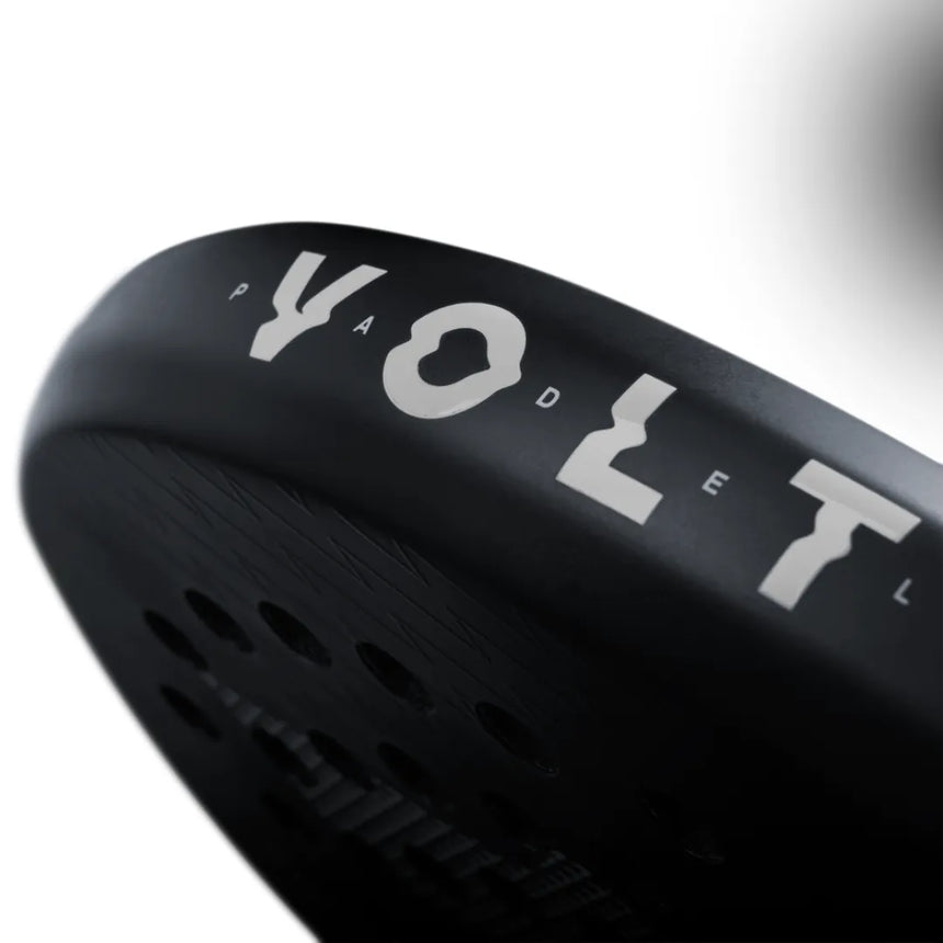 Close-up of a sleek black VOLT 800 V4 padel racket by Volt, highlighting VOLT in white text. The surface has a 3K carbon structure with textured patterns and circular perforations, against a blurred white background.
