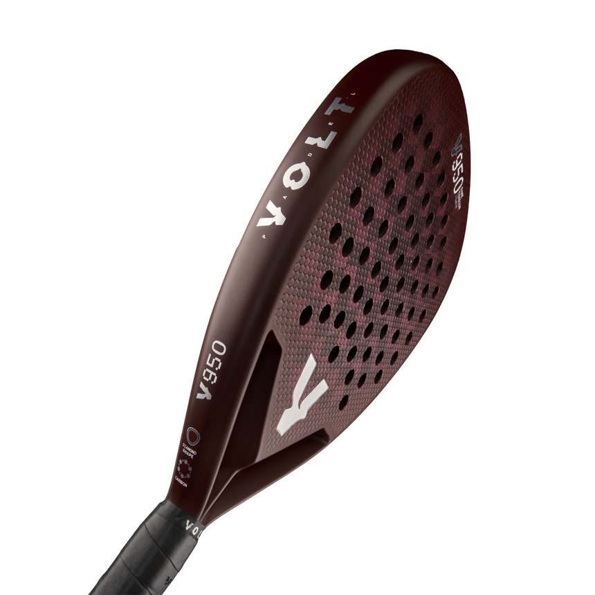 The dark red VOLT 950 V23 padel racket by Volt features a grid pattern of holes for power and control, tailored for advanced players. The brand name and model number appear in white on the surface, paired with a sleek black handle.