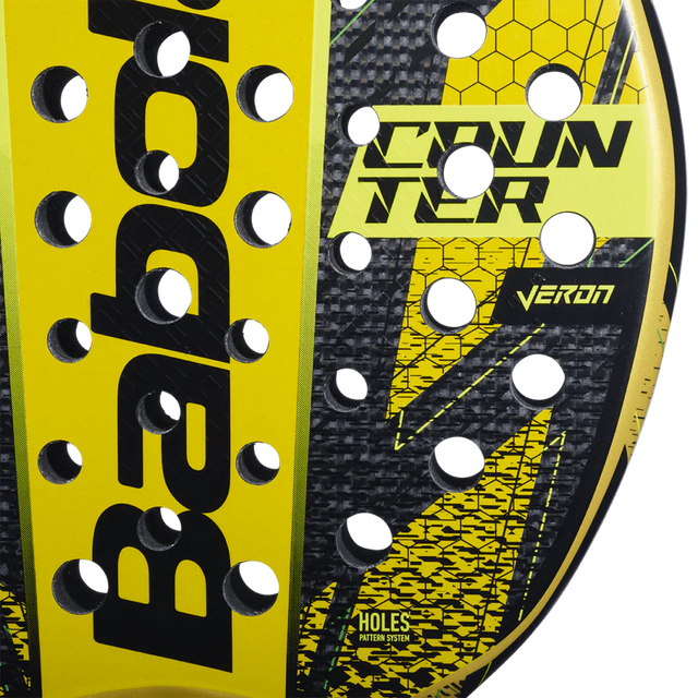 Close-up of a yellow and black Babolat Counter Veron 2024 Padel Racket, showcasing CARBON FLEX technology. The Babolat branding and Counter Veron are prominently displayed on the surface, decorated with a hexagonal pattern and several circular holes.