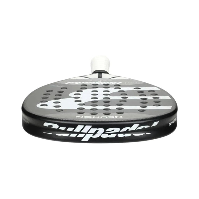 The Padel Smash Academys Bullpadel Padel Racket Neuron 2024 Fede Chingotto features a close-up of its black perforated surface, adorned with a white logo and brand name. The CarbonTube frame complements the design, and the grip is wrapped in white tape.