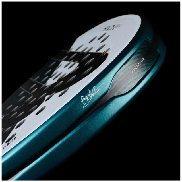Close-up of a teal BULLPADEL RACKET HACK 04 2025 PAQUITO NAVARRO from Padel Smash Academy against a black background. It features Total Channel technology, a signature on the frame, POWER near the edge, and a black and white design with holes.
