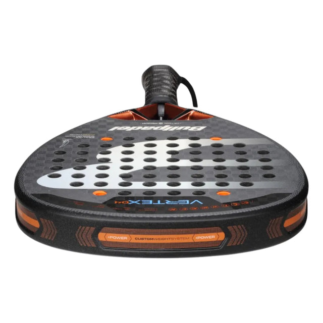 Close-up of the BULLPADEL RACKET VERTEX 04 2025 JUAN TELLO by Padel Smash Academy, like new. It features a black and orange design with a perforated face and wrist strap for total control. Dynamic patterns and branding complete its sleek look.