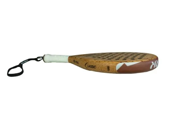 The Cork Padel Classic by Cork Padel features a wooden surface with a grid pattern and an innovative drilling design, plus a white grip and wrist strap for comfort and enhanced control during play.