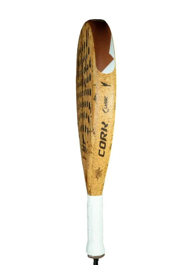 The Cork Padel Classic by Cork Padel features a large brown perforated paddle and a white handle. The word CORX is displayed, highlighting its innovative drilling pattern. Its unique tapering shape and textured head offer comfort and control during play.