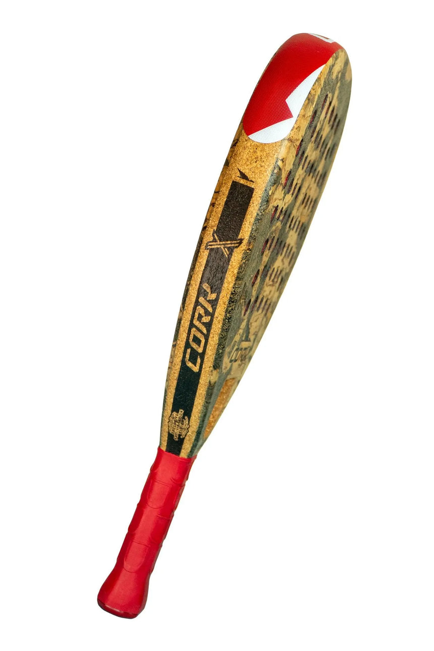 Introducing the limited edition Cork Padel Extreme Red racket, perfect for padel enthusiasts. It features a brown textured honeycomb surface with a red grip and striking branding. The top edge boasts red with a white accent and cutting-edge graphics.