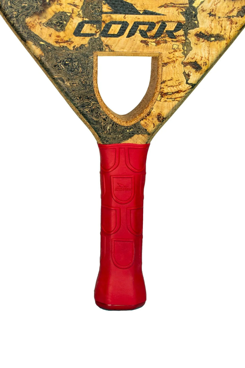 Close-up of the limited edition Cork Padel Extreme Red pickleball paddle by Cork Padel, featuring a distinctive wood-patterned surface. It showcases a vibrant red handle with textured grip, set against a plain white background.