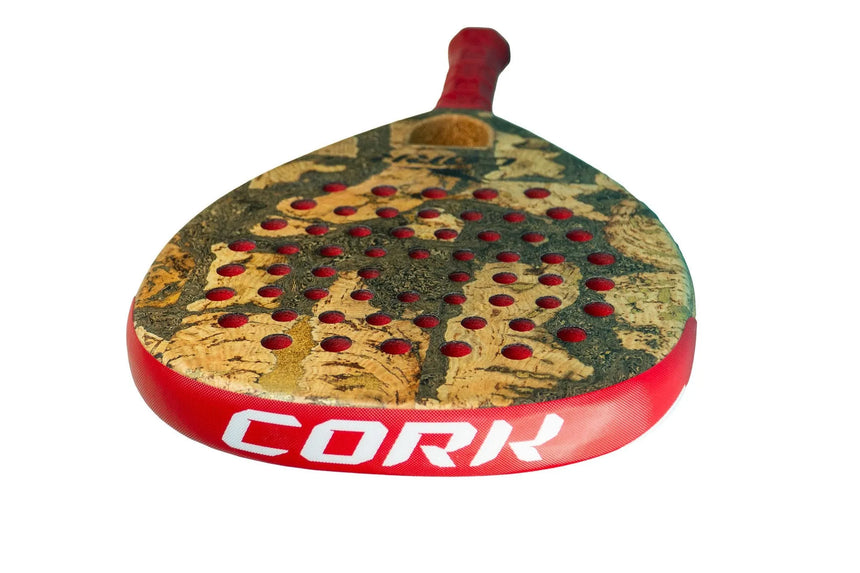 The Cork Padel Extreme Red by Cork Padel is a Limited Edition racket with a cork-textured surface and red perforations, featuring a sleek red edge with CORK in white. Its minimalist design and advanced features make it stand out against the plain white background.