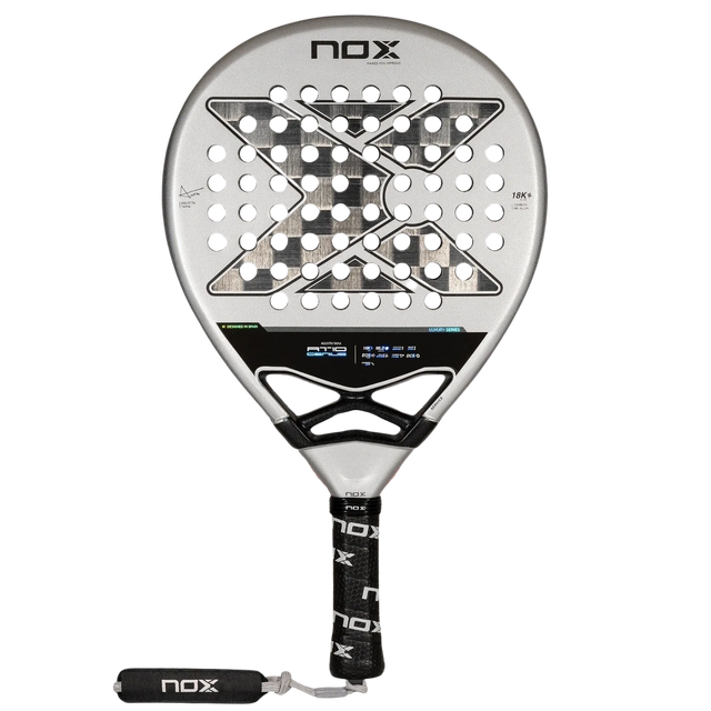The NOX Padel Racket AT10 Genius 18K by 2024 Agustin Tapia features a circular head with a geometric hole pattern, crafted from aluminized carbon fiber for durability. Its gray and black design matches the handle, wrapped in a black grip with NOX branding.