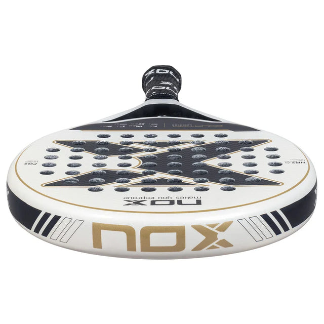 The NOX Padel Racket Equation Advanced Series 2025, with a white and black design, showcases precision and control. It features gold accents, a large X at the center, and comes with a black grip tape on the handle for optimal hold.
