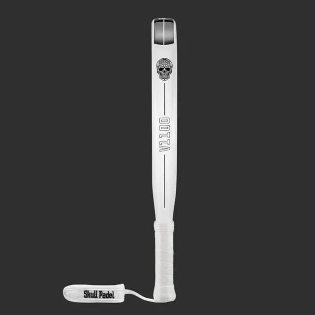 A white SKULL PADEL V1100 - WHITE LEAF 24K racket with a sleek carbon fiber look features a skull graphic at the top and Otta down the side. The wrist strap displays Skull Padel, set against a dark gray background.