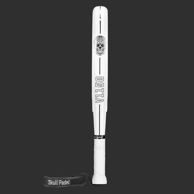 The SKULL PADEL V1150 - WHITE SKULL 24K (LIKE NEW) features a white design with VILLO in black on the handle, a striking skull graphic near the top, and a wrist strap branded with Skull Padel in white. Made from durable carbon fiber, it has an EVA rubber core for improved performance. Black background included.