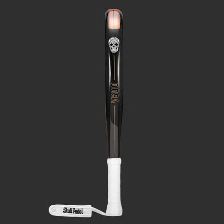 The SKULL PADEL V600 - 12K COPPER SKULL is a like-new padel racket for intermediate players. It has a black and orange design with a skull logo, V800 printed vertically, carbon fiber build, dark gray background, white grip tape handle, and a wrist strap labeled Skull Padel.