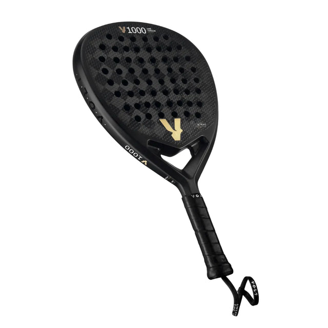 The VOLT 1000 V23 padel racket by Volt boasts a black carbon fiber diamond-shaped blade with a perforated, textured surface. Its sleek design and black handle with wrap and wrist strap enhance aerodynamics, ideal for an aggressive playing style.